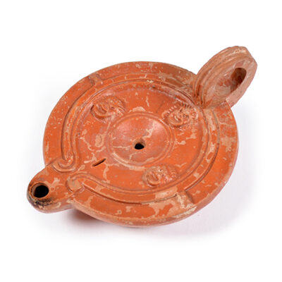 A Roman terracotta red slip ware oil lamp with theatre masks, 1st-2nd century AD